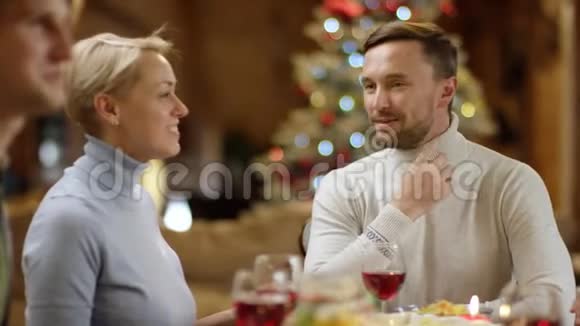 圣诞派对期间可爱的一对情侣在餐桌上聊天视频的预览图