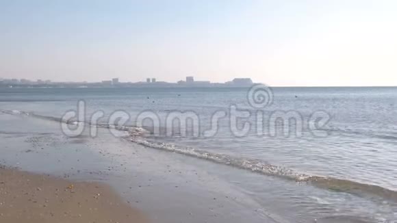 沙滩日落时有波浪可欣赏海岸小镇景色视频的预览图