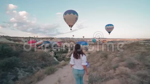 年轻女子日出时带着热气球走来走去稳定镜头视频的预览图