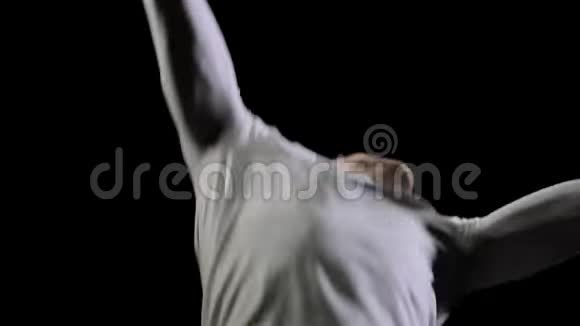 帅气的男性专业体操运动员身穿白色衣服背景为黑色在体操比赛中表演视频的预览图