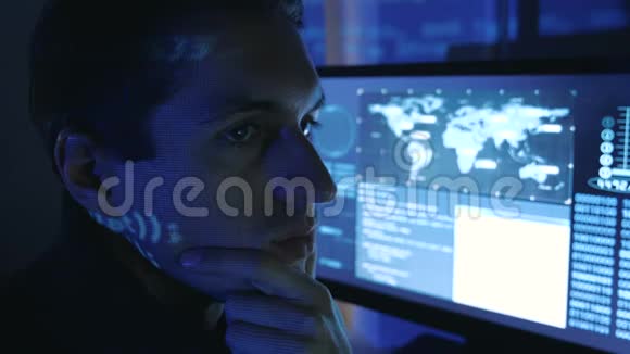 在一个充满监控屏幕的数据中心一个男性专业开发人员程序员的特写肖像哈克作品视频的预览图