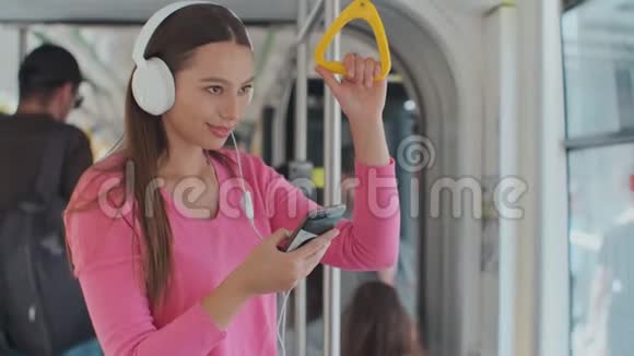 年轻女子在现代电车上移动时握着把手愉快的乘客享受公共交通的旅行视频的预览图