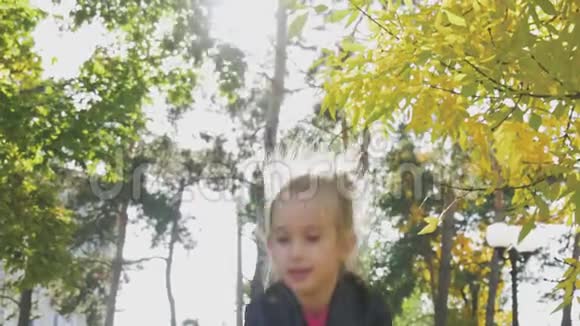 美丽的年轻女孩在公园里扔树叶享受着幸福自由休闲理念秋季儿童放松视频的预览图