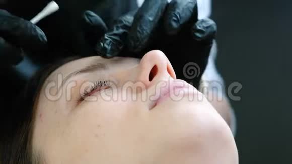 美容师用棉签擦拭病人眼睑睫毛层压板特写眼睛视频的预览图