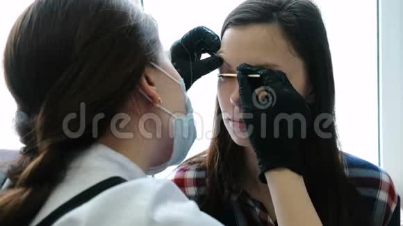 美容师用棉签摩擦客户睫毛睫毛层压板视频的预览图