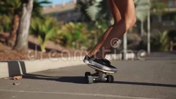 溜冰者的特写他的脚踩在木板上在道路上缓慢行驶的长板车视频的预览图
