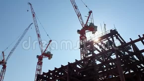 建筑起重机的背景是蓝天和明亮的太阳它隐藏在建筑起重机的后面视频的预览图