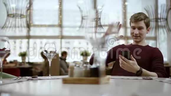 男人坐在餐厅的桌子旁看着账单用卡片付款服务员手里拿着候机厅视频的预览图