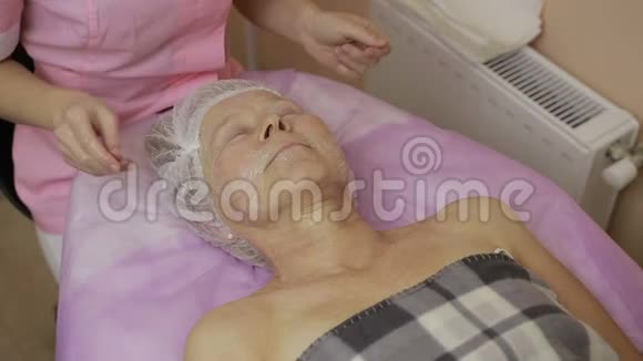 美容师用奶油滋润女人脸视频的预览图