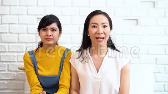 兴奋的亚洲女性看电视视频的预览图