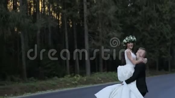 在路上的浪漫情侣新郎把新娘钉在手上慢动作视频的预览图