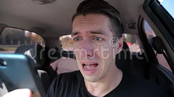 悲伤绝望的男人在手机上读坏短信在车里哭视频的预览图
