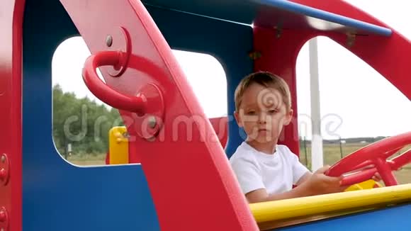 幼儿在操场上转动汽车的方向盘视频的预览图