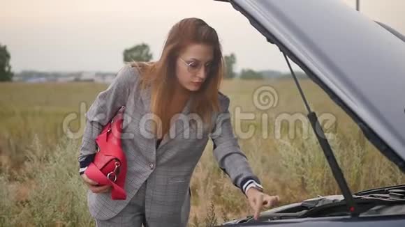 年轻女子因为汽车故障而心烦意乱红发女子不知道车坏的原因汽车视频的预览图