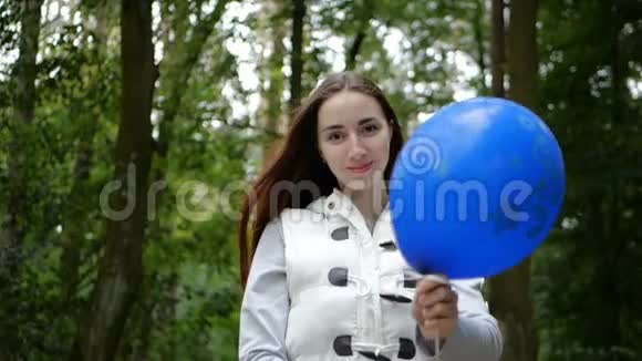 快乐的女人站着在木桶里玩蓝色气球视频的预览图