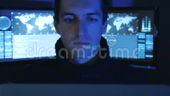 在一个充满监控屏幕的数据中心一个男性专业IT程序员的特写肖像哈克在工作视频的预览图
