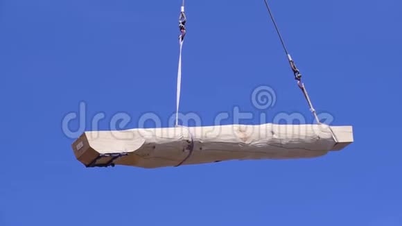 天幕背景的鹤剪辑原木在施工现场用吊车搬运为木屋背景视频的预览图