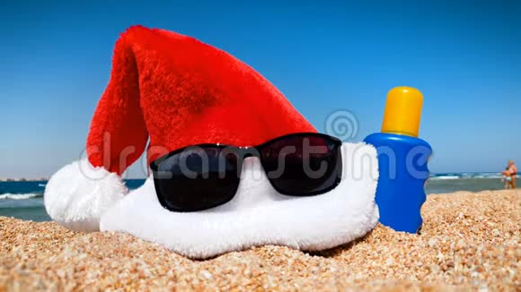 4k圣诞老人帽子的视频带太阳镜和防晒喷雾覆盖海洋和蓝天视频的预览图