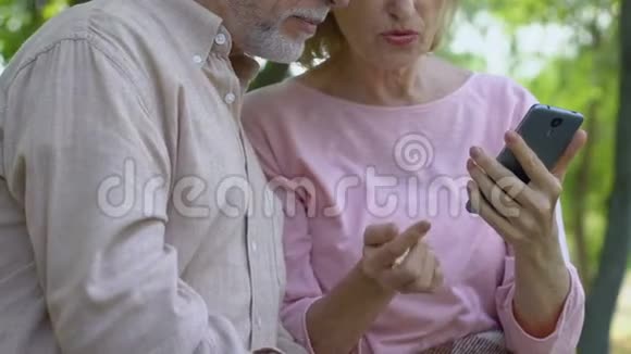 帮助老妇人使用带有触摸屏的智能手机的老人视频的预览图