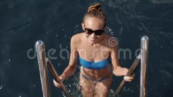 穿着比基尼在海中沐浴在游艇上游弋在船上升起的迷人少女视频的预览图