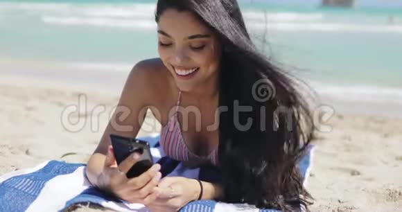 在海滩上用电话的漂亮女孩视频的预览图