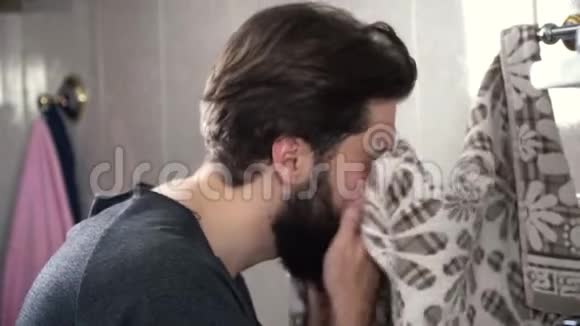 人用毛巾擦脸白天从照顾面子开始一个英俊严肃蓄着胡须的男人洗衣服视频的预览图