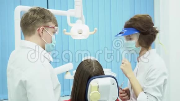 戴口罩和护目镜的男女牙医媒体戴防护无菌制服的牙科医生视频的预览图