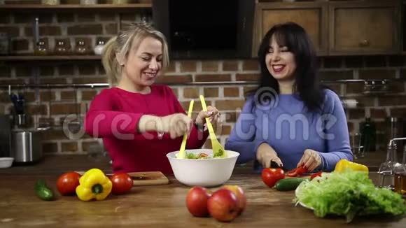 快乐的中年妇女搅拌一碗沙拉视频的预览图
