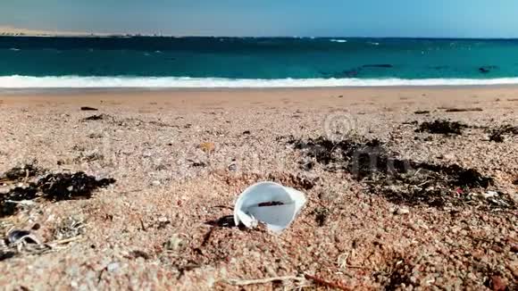 塑料杯花园和碎片躺在塞萨海滩的4k视频污染和自然灾害的概念视频的预览图