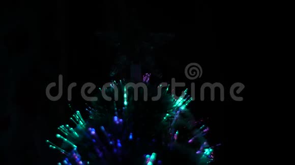 人造圣诞树用花环和圣诞星装饰暗室里圣诞树的亮光视频的预览图