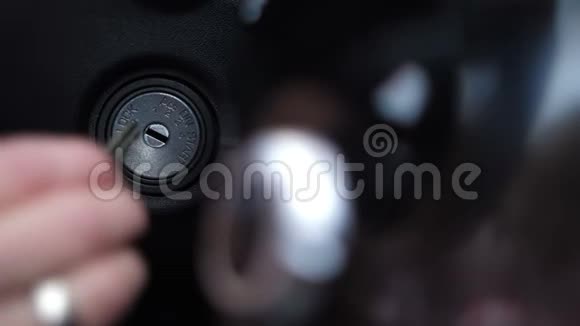 特写镜头女性手将钥匙插入点火装置面板上的按钮亮起4K慢速莫视频的预览图