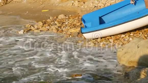 空的蓝白渔船在海滨海浪拍打着海岸视频的预览图
