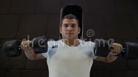 强壮的男人在健身房用哑铃做运动视频的预览图