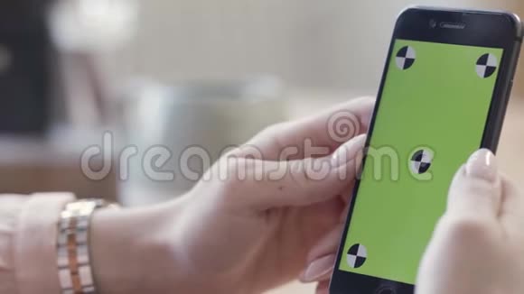 关闭女士手握智能手机与绿色屏幕显示在垂直位置库存录像女性视频的预览图
