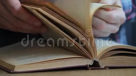 一个人用俄语翻阅一本书用手指翻阅书页研究书页视频的预览图