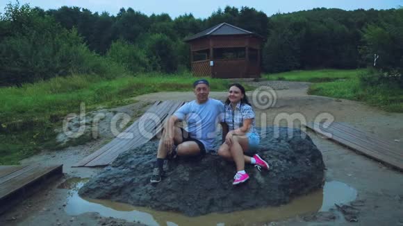 两个男人和女人坐在一块巨大的石头上满足了欲望视频的预览图
