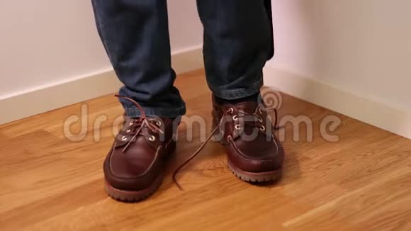 穿牛仔裤的人穿上和系深棕色的鞋子背景视频的预览图