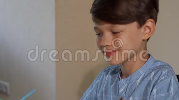 可爱的小男孩一边画一边对着镜头微笑视频的预览图