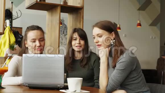 女同事用笔记本电脑讨论咖啡馆的联合项目视频的预览图