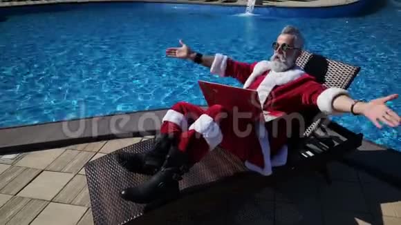 圣诞老人在游泳池里放松用手提电脑开疯狂的玩笑视频的预览图