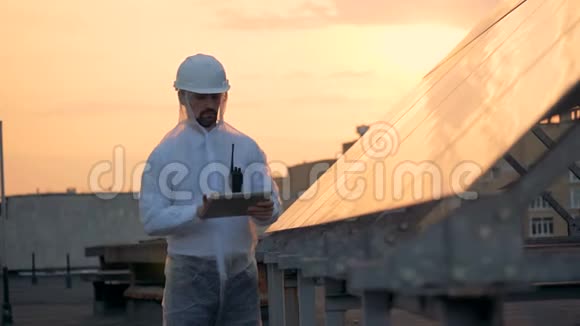 太阳装置和一名男性专家在日落时在附近工作视频的预览图