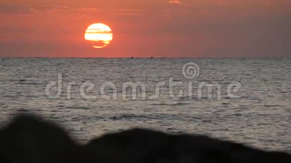 在海面上巨大的圆圆的红色的日落或黎明在海面上反射阳光和日出视频的预览图