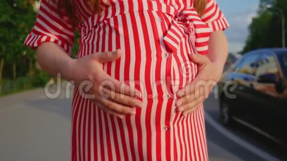 孕妇腹部特写怀孕的女孩在夏天抚摸她的大肚子中弹视频的预览图