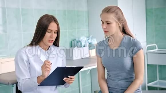女医生穿着白大褂与生病的女孩讨论症状投诉诊断视频的预览图