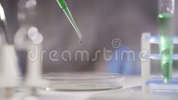 在一个未来的实验室里一位拿着吸管的科学家分析了一种有色液体来提取DNA和分子视频的预览图