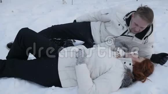一对躺在雪地里的夫妇视频的预览图