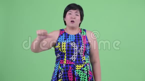 悲伤的年轻超重的亚洲女人竖起大拇指视频的预览图