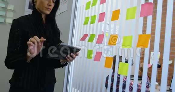 女性高管使用数码平板电脑4k去除粘便条视频的预览图