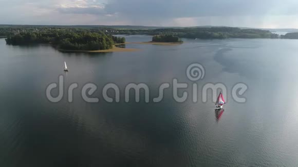 两艘游艇漂浮在湖面上带帆船游艇的景观水湾里的帆船表演视频的预览图