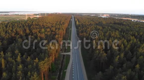 空中日出拍摄城市外的道路在一个乡村森林与卡片和卡车通过购买跟随车辆拍摄视频的预览图